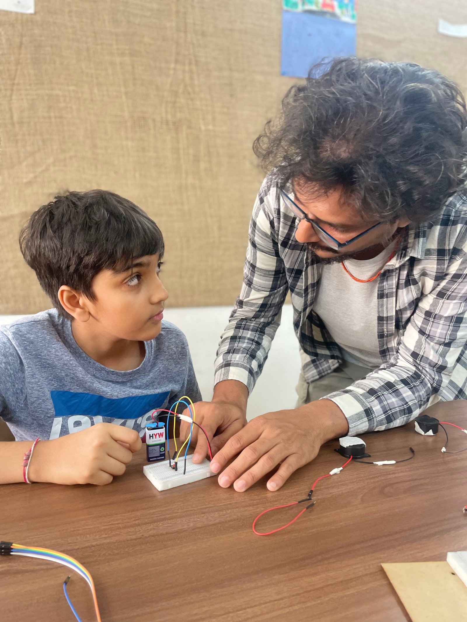 Instructor guiding a student in robotics at ArCoBotics