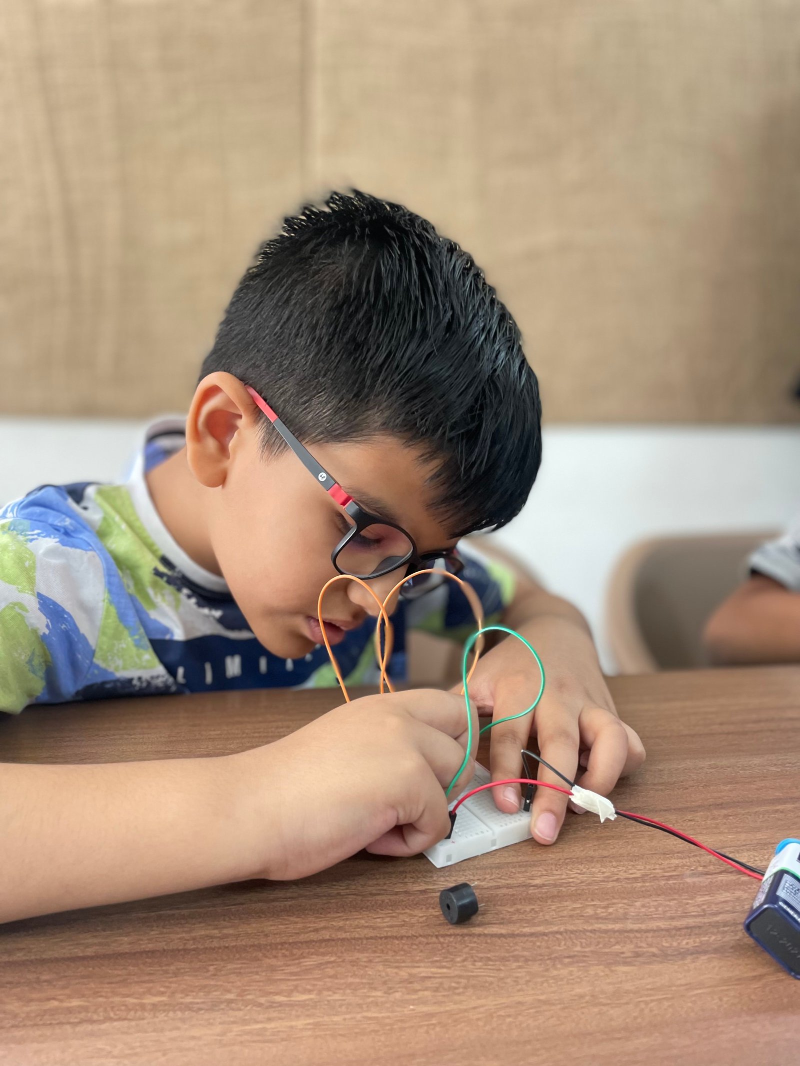 Boy concentrating on electronics project at ArCoBotics