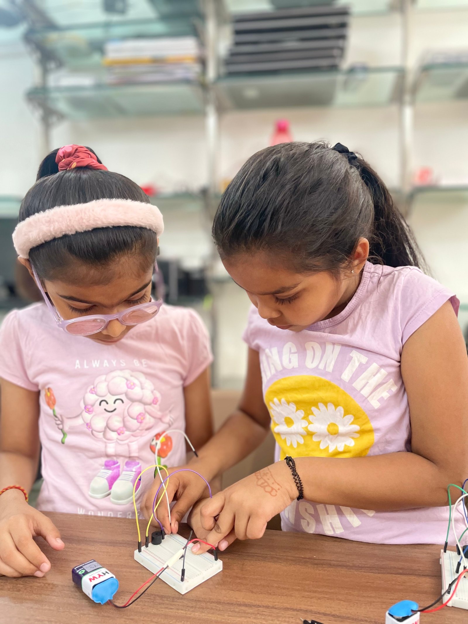 Two girls working on a robotics project at ArCoBotics